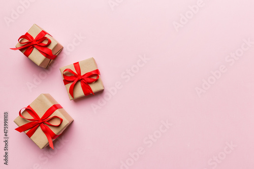 Valentine day composition: red gift box with bow and heart. Christmas present. View from above. Space for text. Holday greeting card