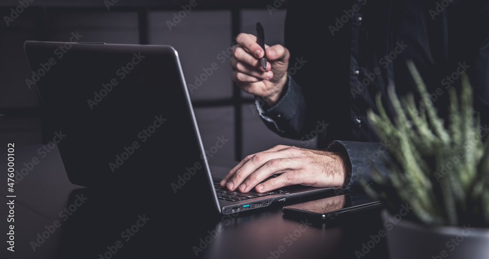 Businessman using a smartphone and notebook in a moddy office Businessman using a smartphone and notebook in a moddy office