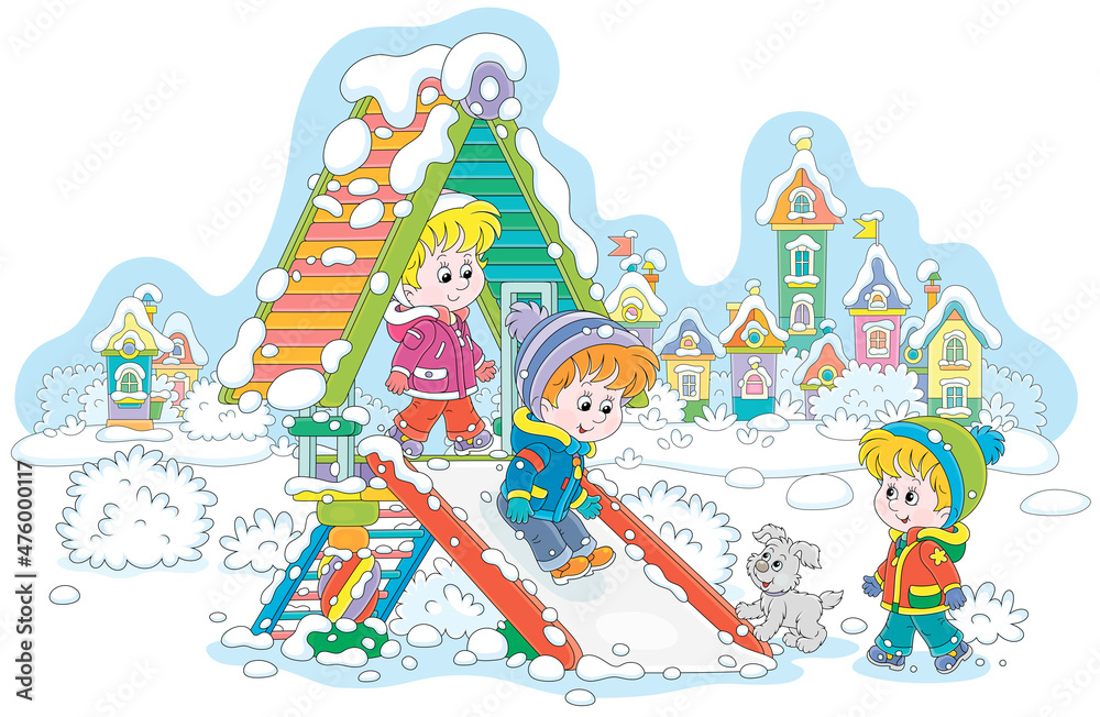 Merry little children playing on a colorful toy slide on a snow-covered  playground in a