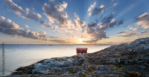 a colorful sunset of a red little fisherman's hut at the coast of sweden. Longe exposure