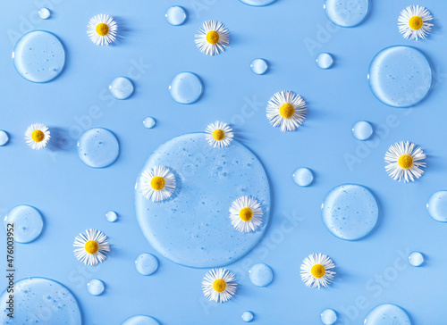 serum drops on blue background transparent gel serum with chamomile flowers with place for text