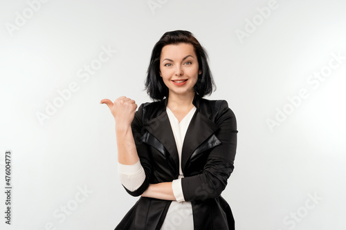 Pretty woman looking happy, pointing aside at left copy space, presenting your product, recommend follow link, click on banner, standing over white background