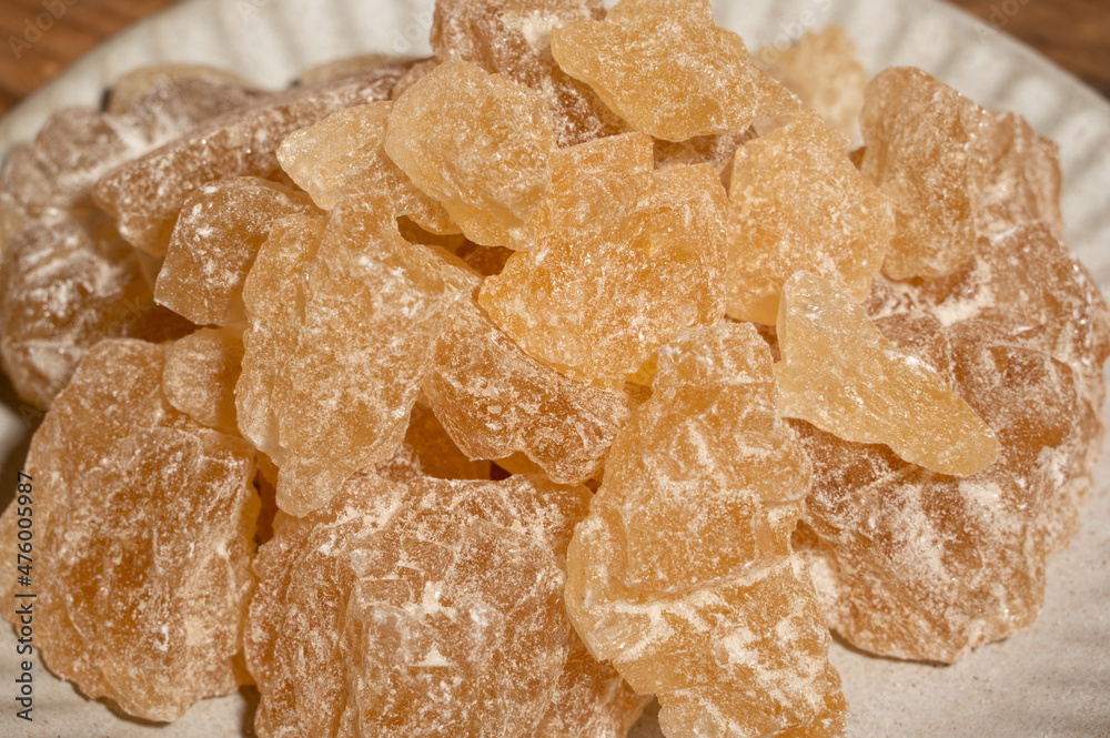 The rock sugar in the container is on the wood grain table The rock sugar in the container is on the wood grain table