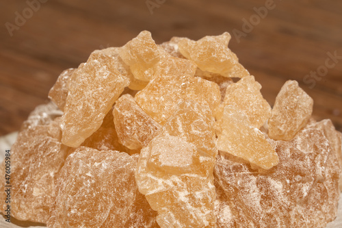 The rock sugar in the container is on the wood grain table
