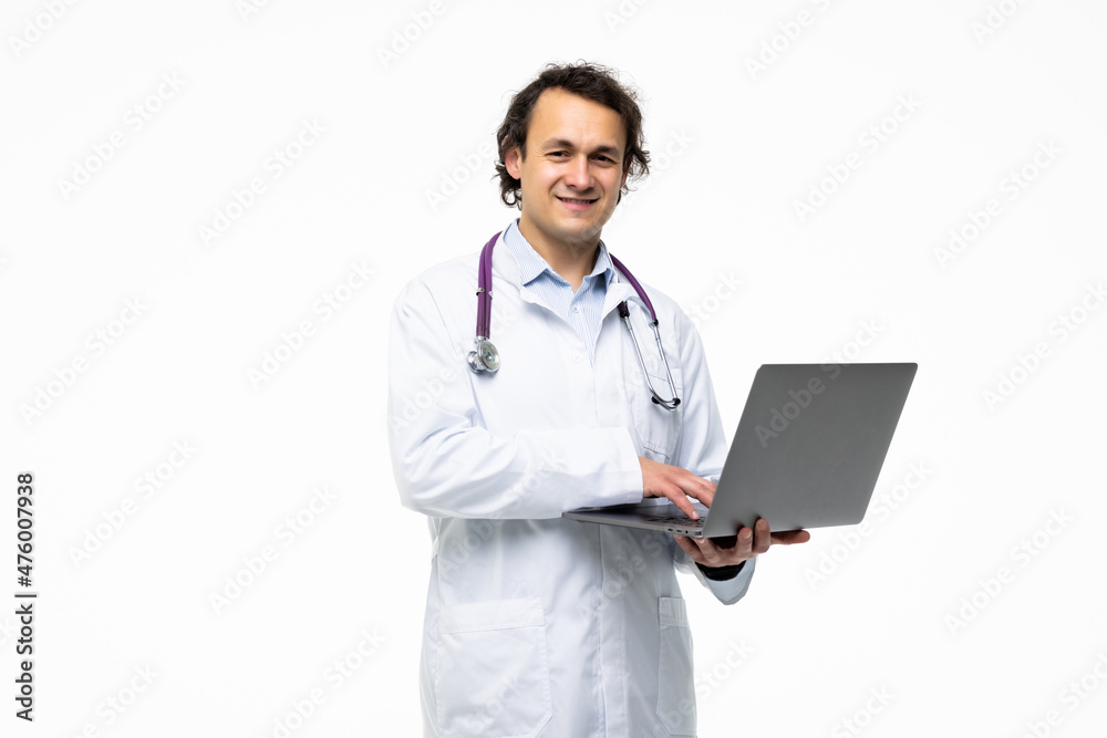 Concentrated male doctor using laptop over grey background. Concentrated male doctor using laptop over grey background.