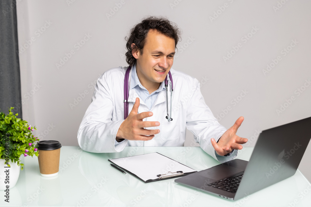 Doctor Having Video Conference On Laptop With Colleagues in office Doctor Having Video Conference On Laptop With Colleagues in office
