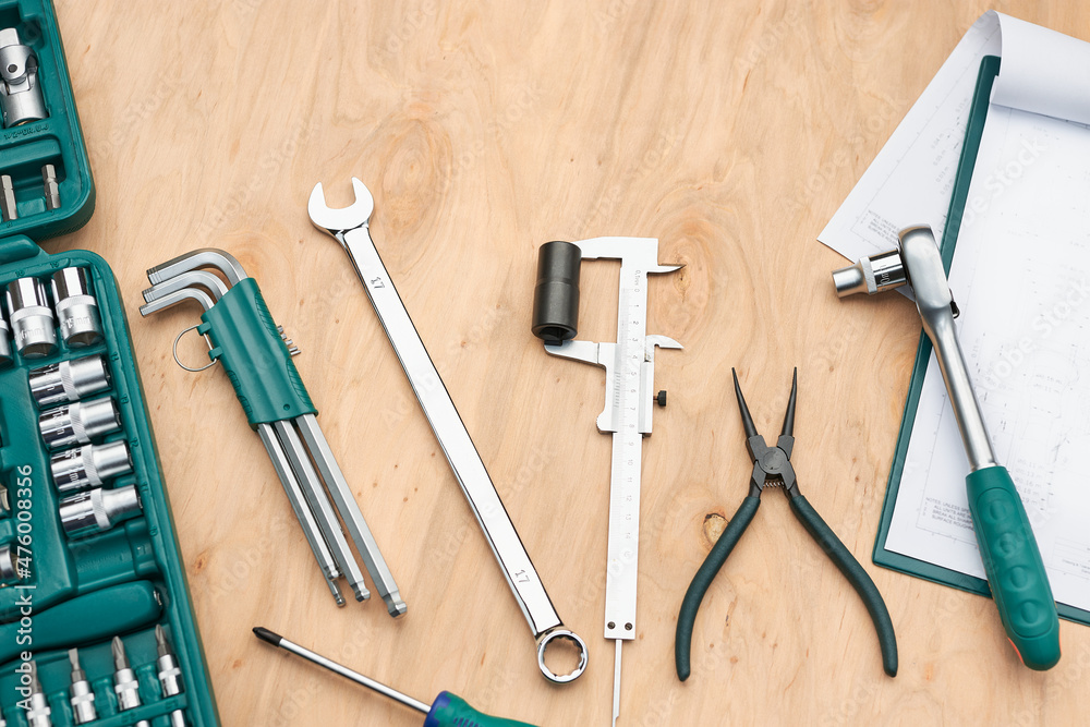 Workshop table with many tools. Wrench, spanner, calliper and ratchet with many attachments. Work tools. Universal tool set. Professional equipment Workshop table with many tools. Wrench, spanner, calliper and ratchet with many attachments. Work tools. Universal tool set. Professional equipment