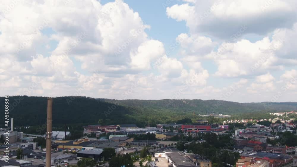 Industrial chimney and living buildings of small town in Sweden, aerial tilt down shot Industrial chimney and living buildings of small town in Sweden, aerial tilt down shot