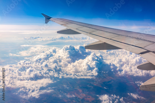 View from the airplane window at a beautiful cloudy sky and the airplane wing