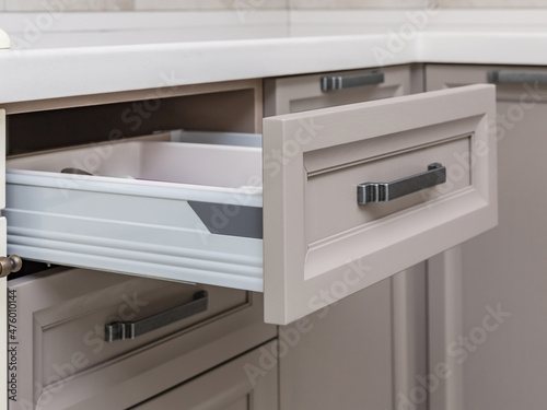 Kitchen cabinet with an open drawer extension on roller guides. Kitchen furniture.