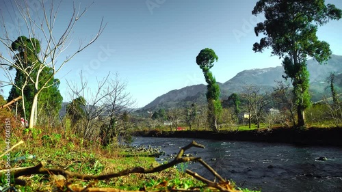 mountain river on the background of big mountains in Georgia. A clear sunny day in the countryside. Autumn, the leaves on the trees are colorful. Autumn colors in a mountain valley. photo