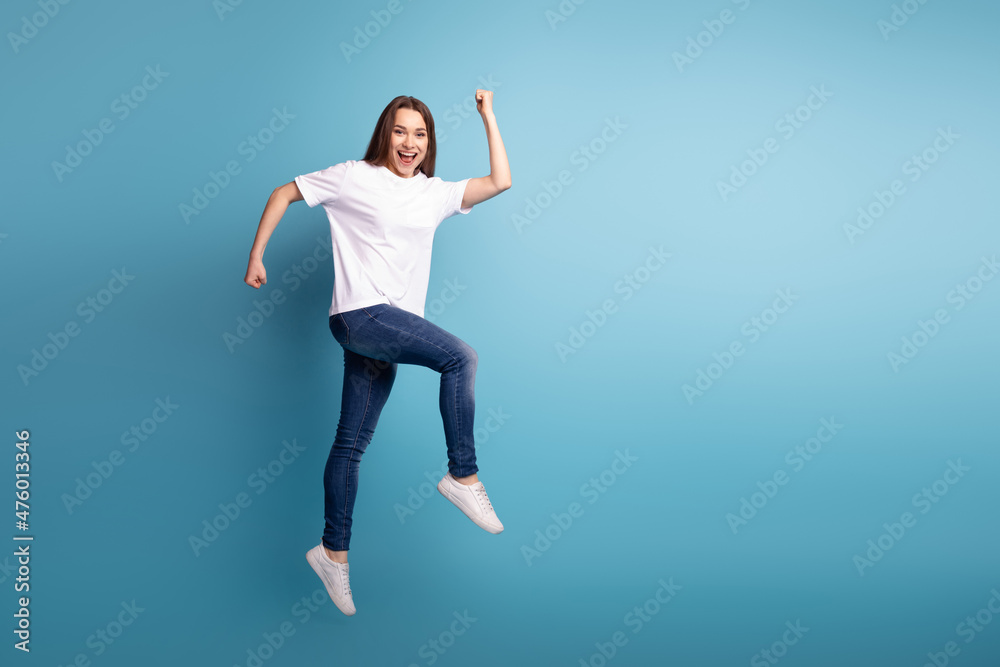 Full length profile side photo of young excited girl run rush jump season isolated over blue color background
