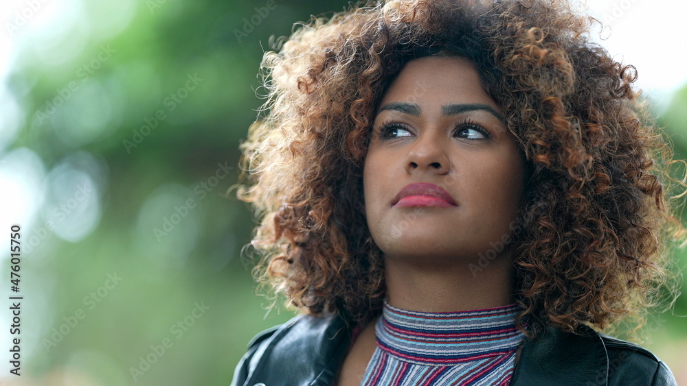Fototapeta premium Pensive African descent woman. Contemplative Brazilian girl standing outside