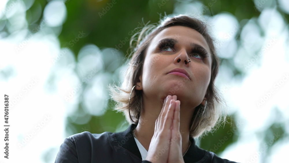 Hopeful woman looking up at sky smiling praying with HOPE and FAITH Hopeful woman looking up at sky smiling praying with HOPE and FAITH