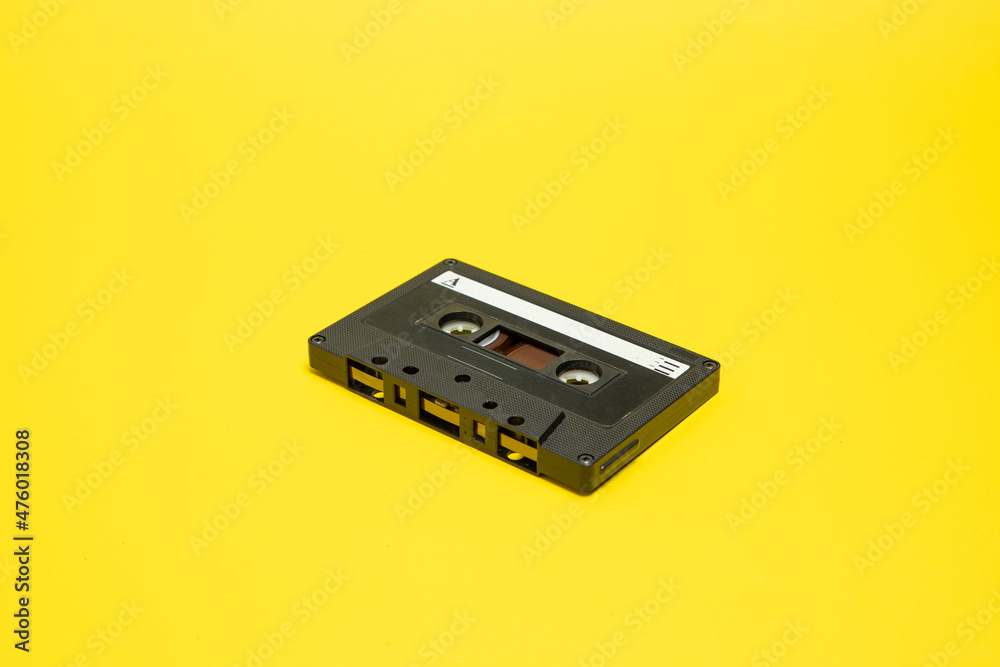 Black audio cassette, tape on a yellow background. Cool musical and retro idea
Black audio cassette, tape on a yellow background. Cool musical and retro idea