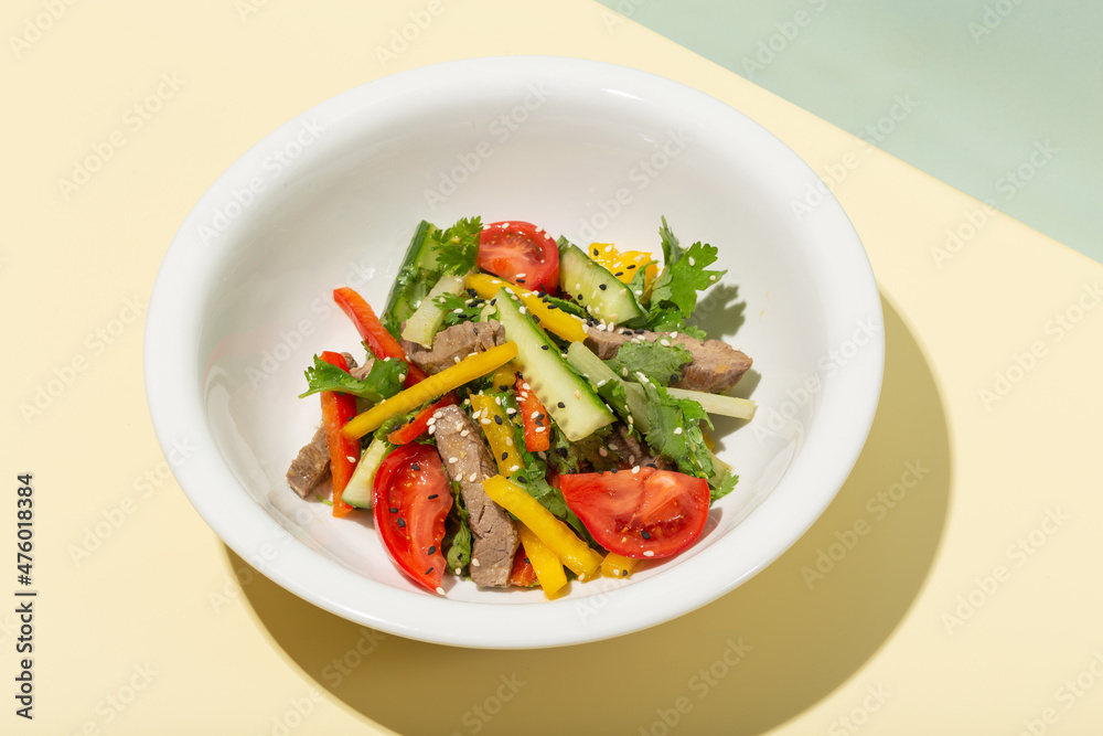 Grilled Beef Steak salad with greens vegetables. Healthy food. Hard shadows Grilled Beef Steak salad with greens vegetables. Healthy food. Hard shadows