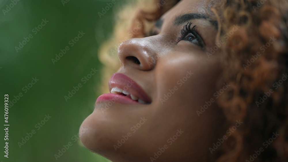 African woman taking a deep breath outside in nature looking up at sky smiling feeling free African woman taking a deep breath outside in nature looking up at sky smiling feeling free