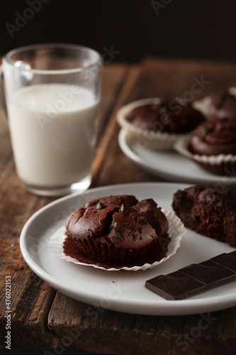 Food photo. Chocolate muffins and a glass of milk on a wooden background