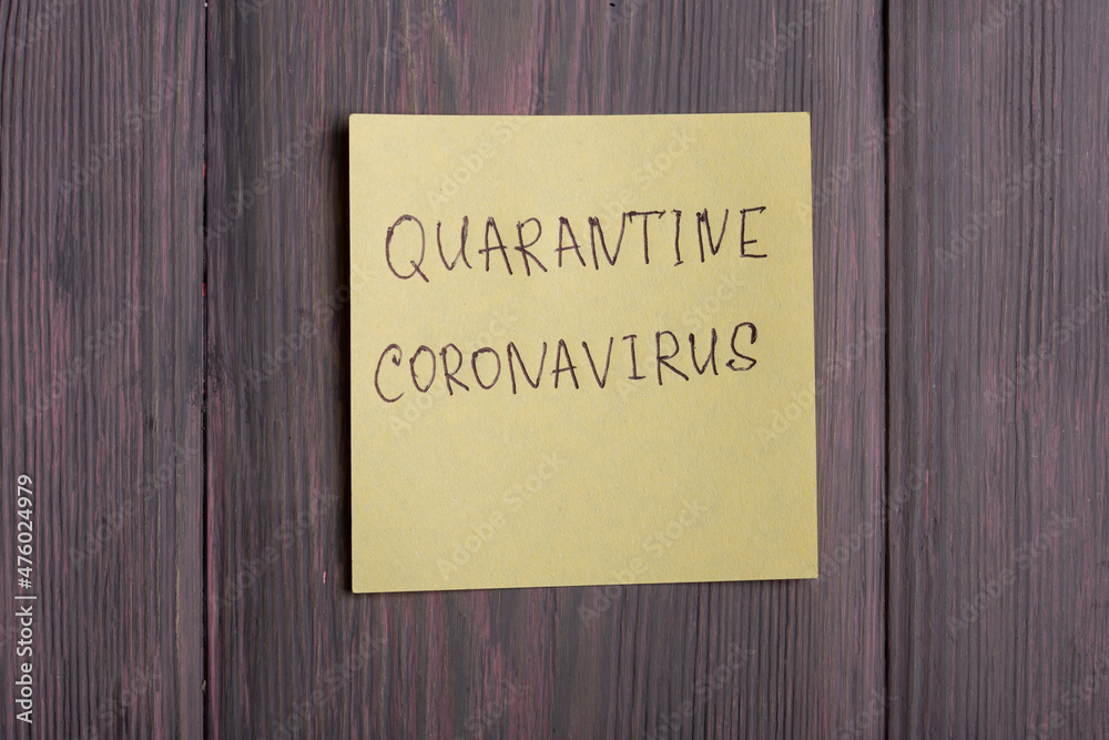 Text quarantine Coronavirus on sticky note on wooden background Text quarantine Coronavirus on sticky note on wooden background