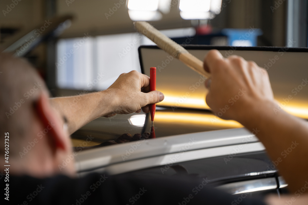 Process of Repairing Dents On Car Body. Technician Is Working Using Professional Tools For Paintless Dent Repair. Man Is Repairing Dents On Car Roof After Hail. PDR Removal Course Process of Repairing Dents On Car Body. Technician Is Working Using Professional Tools For Paintless Dent Repair. Man Is Repairing Dents On Car Roof After Hail. PDR Removal Course