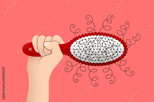 Hair brush with tuft of fallen hair in woman's hand