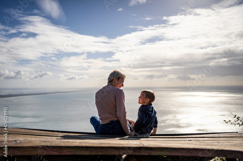 Mother and 3 years old son talking to each other having the beautiful ocean view, Portugal