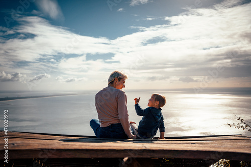 Mother and 3 years old son talking to each other having the beautiful ocean view.iew,
