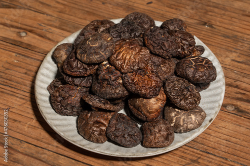 Dried mushrooms in a container on a wooden countertop