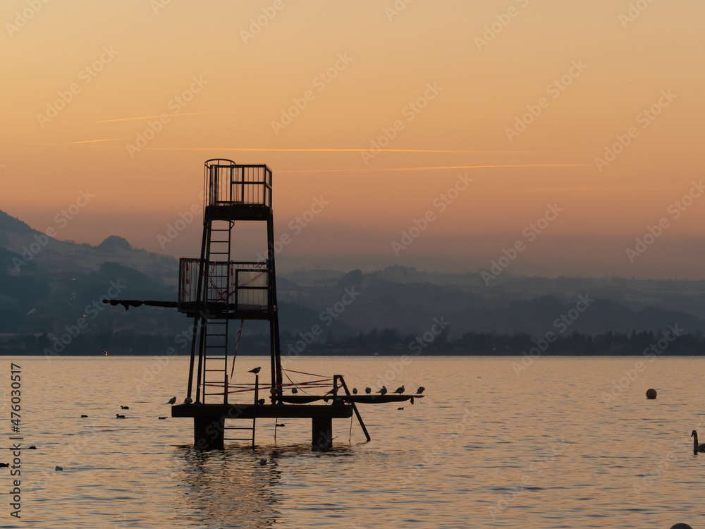 Stunning sunset over the shores of the Upper Zurich Lake (Obersee) with idle bathing facilities in the foreground, Stampf, Rapperswil-Jona, St. Gallen, Switzerland
