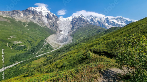 A panoramic view on the snow-capped peaks of Tetnuldi, Gistola, Lakutsia and the Adishi Glacier in the Greater Caucasus Mountain Range in Georgia, Svaneti Region. Sharp peaks, wanderlust, solitude. © Chris