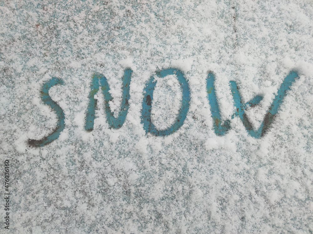 Word snow is written in the snow on an old painted surface Word snow is written in the snow on an old painted surface