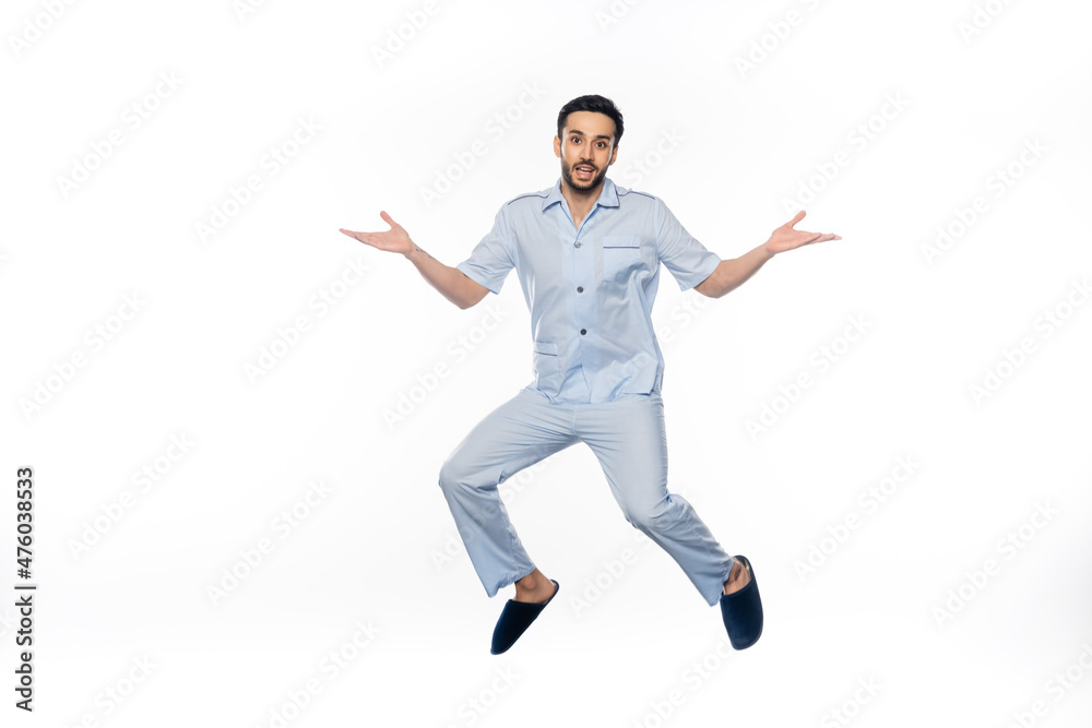bearded man in pajamas levitating while gesturing on white. bearded man in pajamas levitating while gesturing on white.