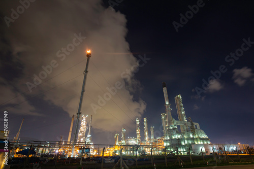 Oil    refinery    and tower flare fire of petrochemistry industry in oil    and    gas       industry with    cloud    blue       sky traffic light road transportation truck