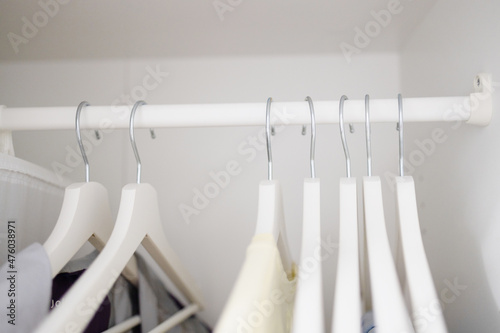 Women clothes hanging on wooden hangers in the closet. Fashionable casual clothes. Shopping. © Shi 