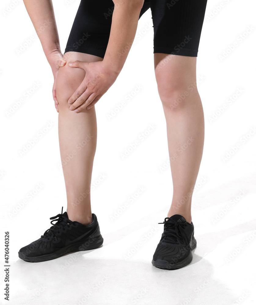 Woman in sportswear is holding her painful knee joint