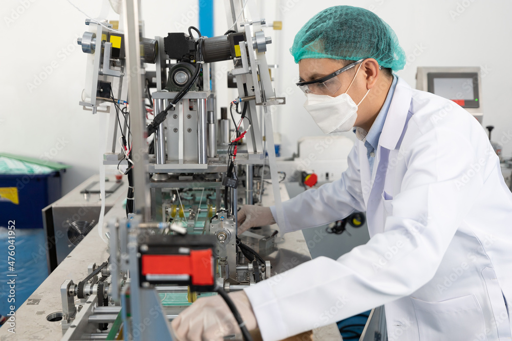 factory worker using machine control panel and producing medical face masks in factory factory worker using machine control panel and producing medical face masks in factory