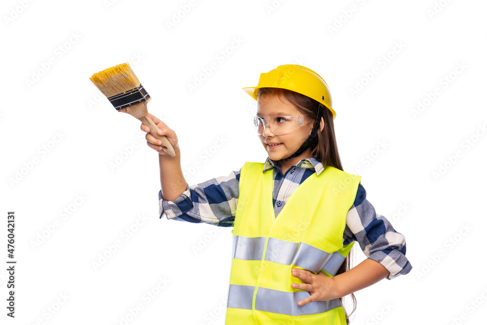 building, construction and profession concept - smiling little girl in protective helmet and safety vest with paint brush over white background