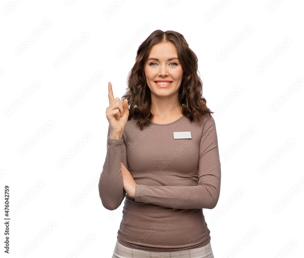 sale, shopping and business concept - happy female shop assistant with name tag pointing finger up over white background sale, shopping and business concept - happy female shop assistant with name tag pointing finger up over white background