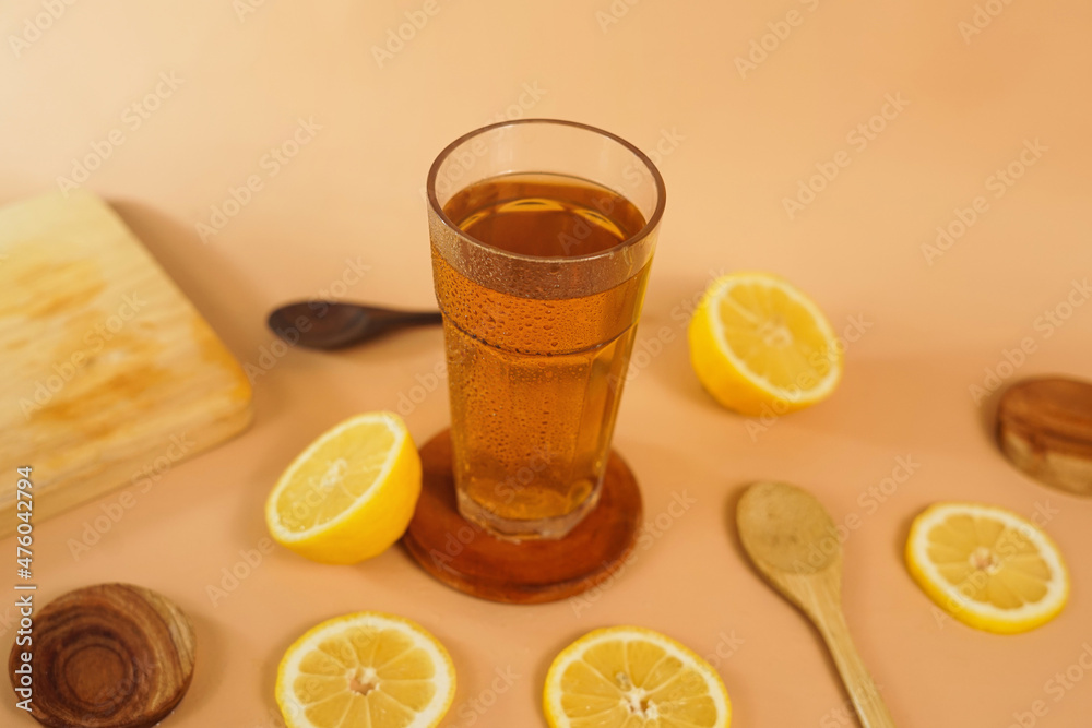 a glass of tea photographed with sliced oranges and utensils decorating. a tempting beverage for background or advertisement.