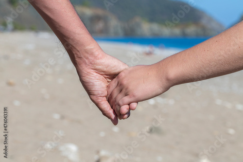 Couple hands held together on a natural sea background, close up © OlegD