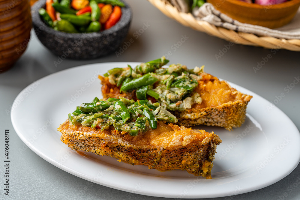 Fresh cut of deep fried Mackerel fish with sambal ijo. fried Mackerel fish cabe ijo is traditional cuisine from Padang, West Sumatra.