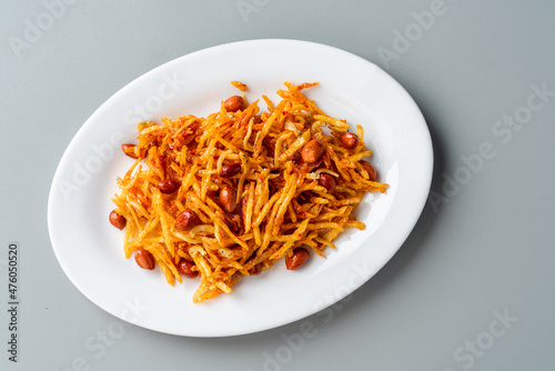 Sambal teri kentang is minang cuisine of West Sumatra, Indonesia. Served on white plate and isolated on gray background.