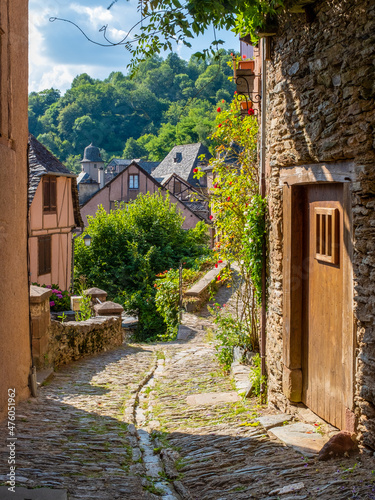 A typical narrow cobblestone street of Conques, France photo