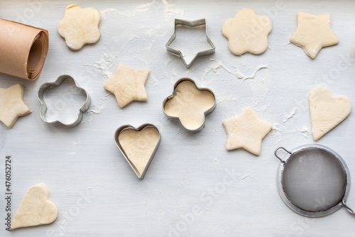 Top view of woman hands cooking a gingerbread cookie in the form of heart, star, cloud and flower. Christmas and New Year concept, festive preparations for winter hilodays
