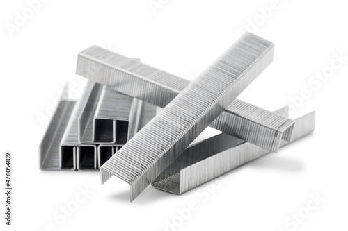 Stack of metal staples for stapler gun isolated on white background, close up. Industrial tool.