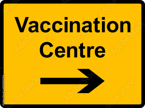 Covid vaccination centre here sign. Black on yellow background. Directional signs and symbols.