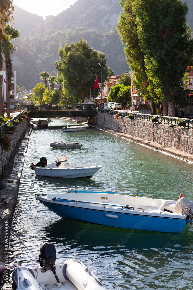 Naklejka premium Motor boats moored at the water channel. Small fisher boat tied on river in small tourist village.