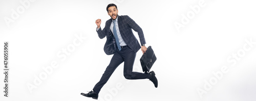 positive businessman in suit jumping with briefcase on white, banner.