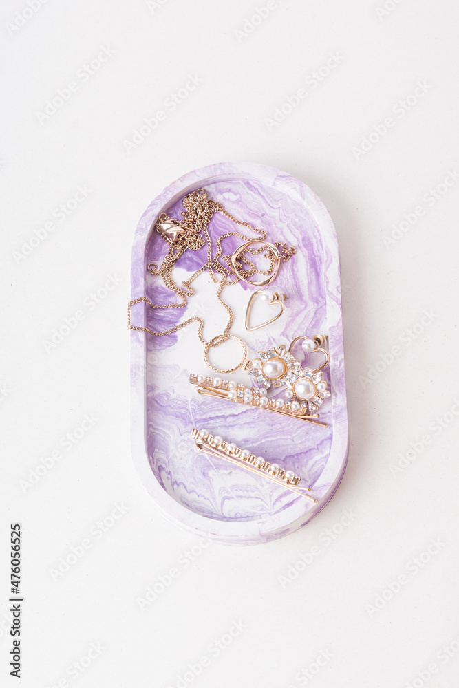 Earrings and rings in purple plaster tray. Storage system for women's jewelry. Top view Earrings and rings in purple plaster tray. Storage system for women's jewelry. Top view