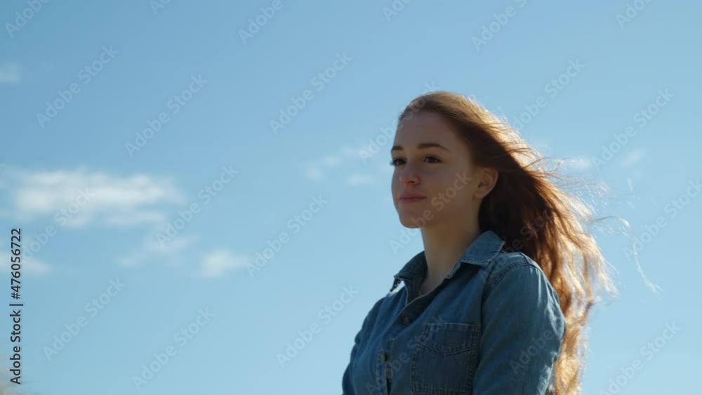 Redheaded woman riding a horse against bleu sky Redheaded woman riding a horse against bleu sky